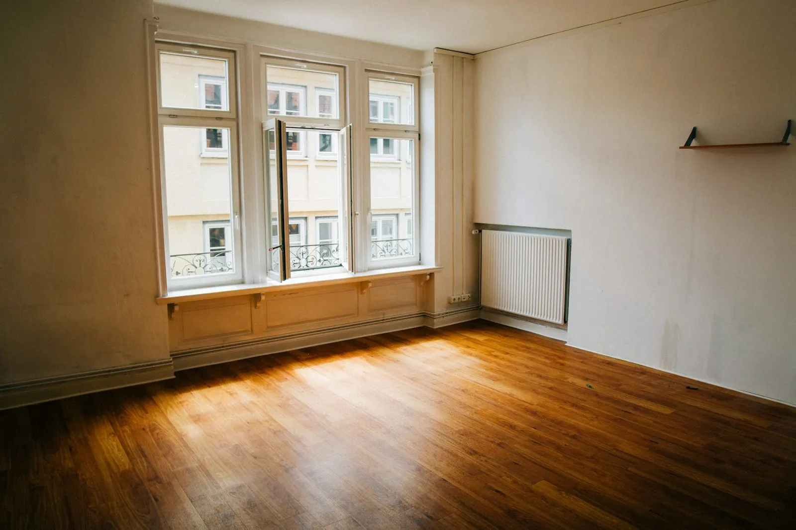 Pièce vide avec parquet et grandes fenêtres