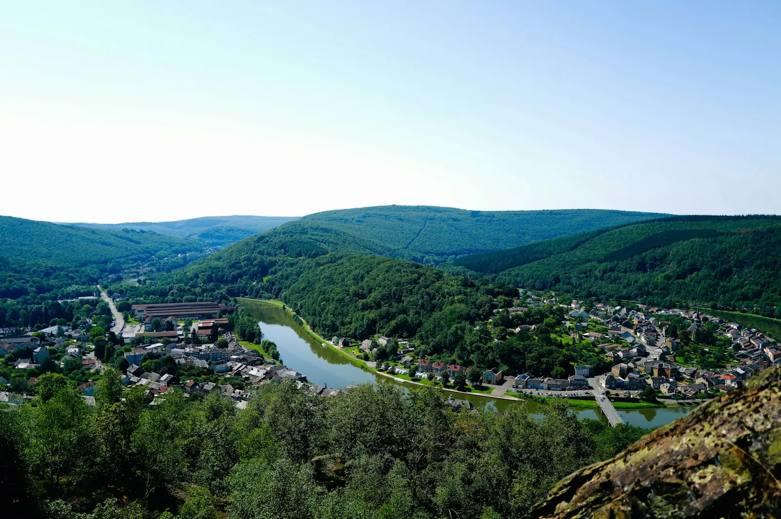 Vallée boisée et maisons au bord d’une rivière